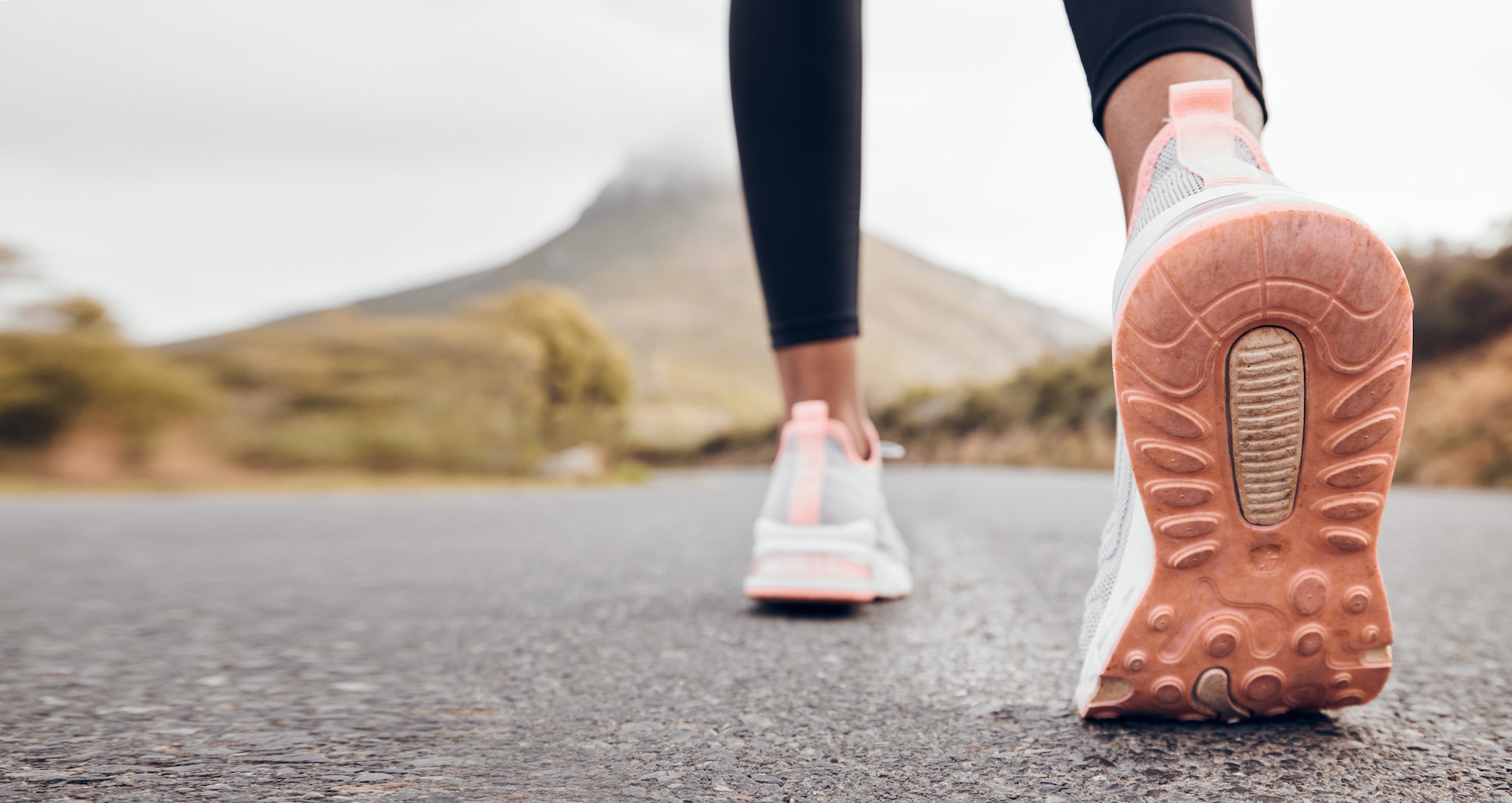 Shoes, athlete and road by a mountain outdoor ready to start a run for health and wellness. Feet, p