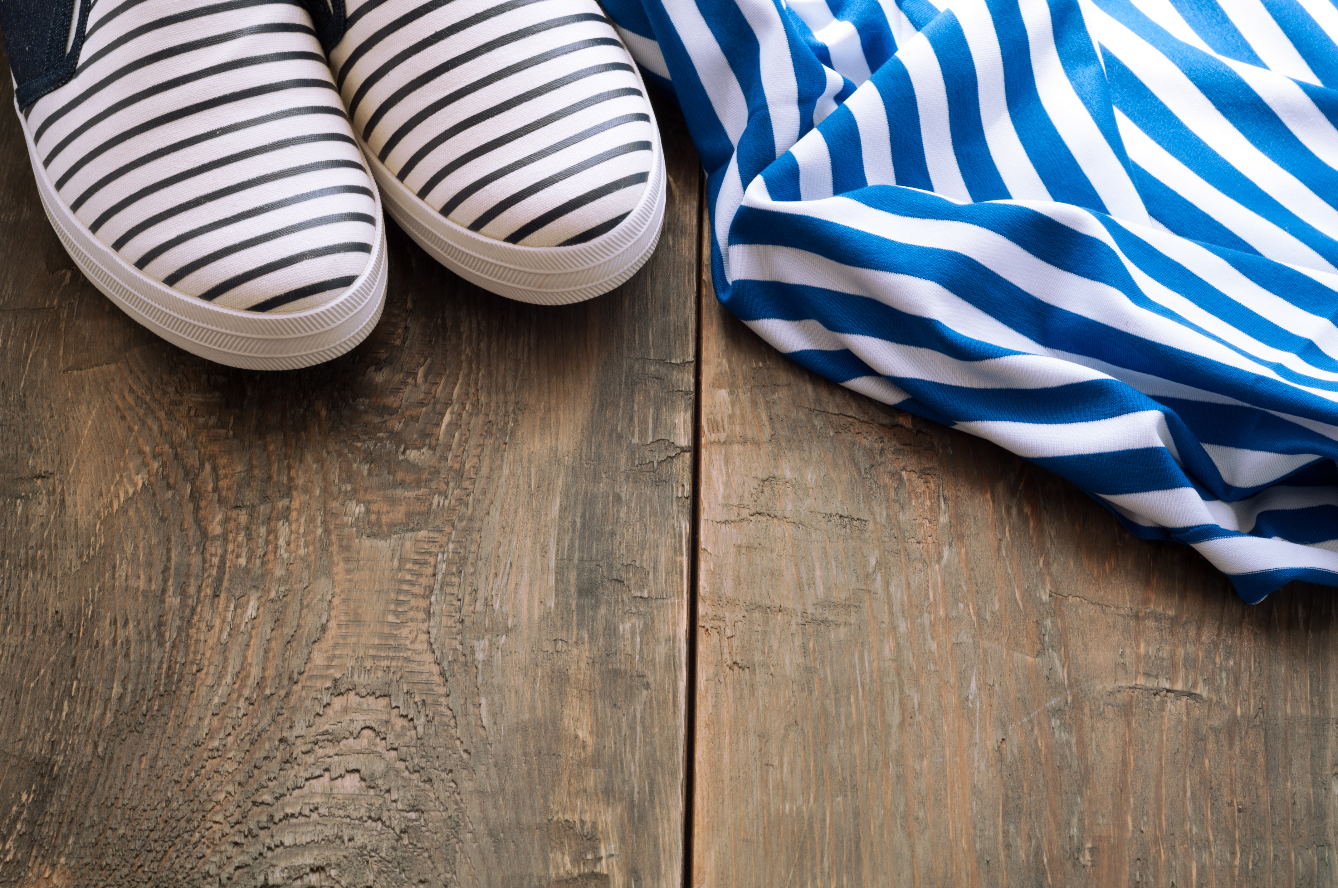 Shoes and striped cloth on old wooden background