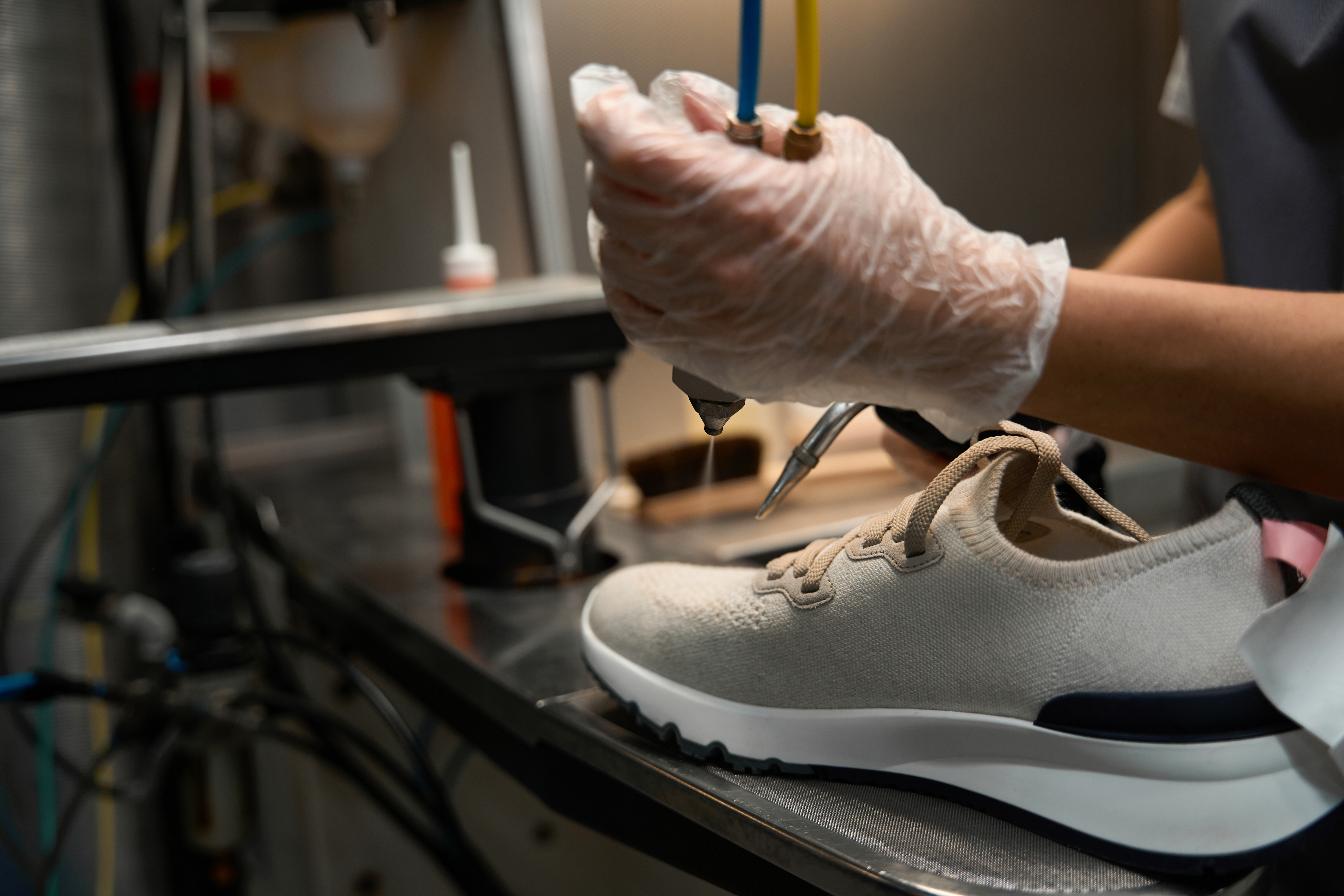 Woman dry cleaning operator spraying solvent on dirty sneakers